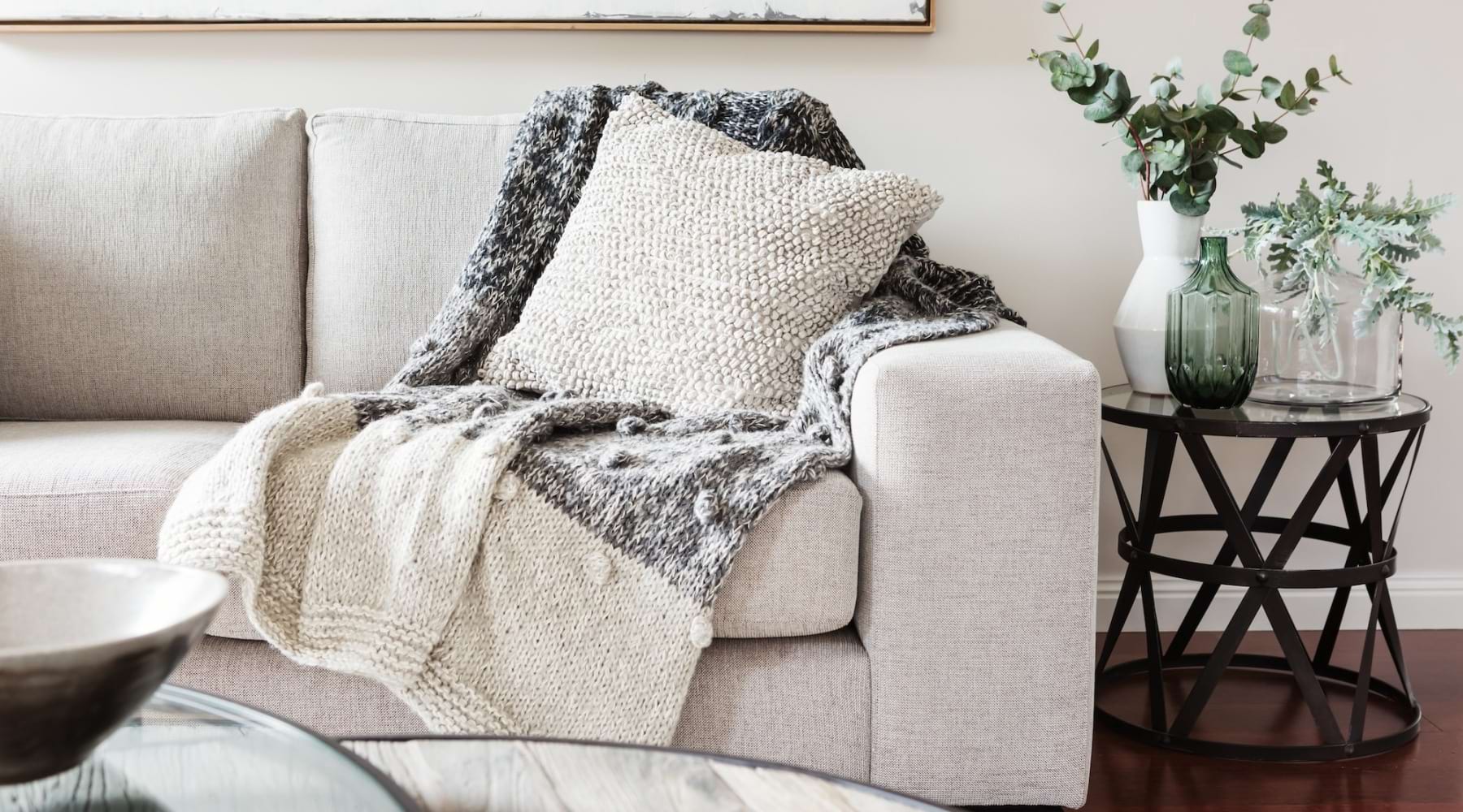 a couch with a blanket and a pillow on it with tables